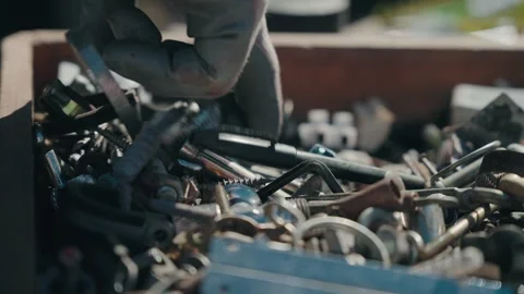 Hand selecting metal screws and bolts from hardware box Stock Footage 331982258