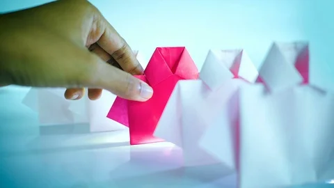 Hand selecting one Red among white origami shirt paper , best choosing of rec 動画素材 117658147