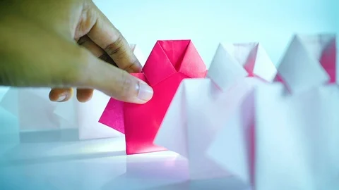 Hand selecting one Red among white origami shirt paper 動画素材 117660057