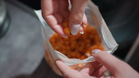 Hand Selecting Orange Berries From Resealable Bag In Kitchen, Closeup Of Fingers 库存影片 330801516