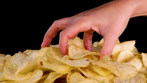 Hand Selecting Potato Chips from Pile on Black Background Stock Footage 318442175