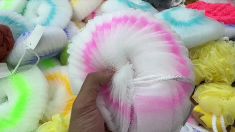 Hand Selecting a Soft Pink and White Shower Puff from a Diverse Assortment .. Video stock 326035858