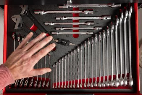 Hand selecting tool from organized workshop drawer Stock Photos