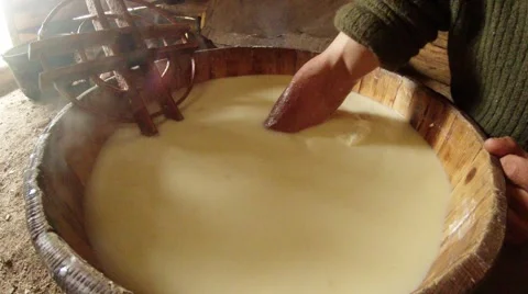 Hand selects hot cheese from a large pot on the old traditions of the mountains Stock Footage 43225191