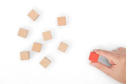Hand selects red block from block group Stock Photos