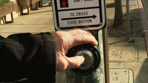 Hand of a senior man pressing the button of a pedestrian crossing. 스톡 동영상 88372491