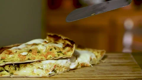 Hand separating a triangular piece from a steaming half tart of vegetables .. Stock Footage 252326571