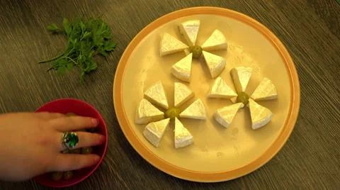 Hand serve snack on a plate you spread cheese olives and herbs Stock Footage 59142798