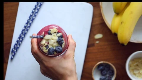 Hand serves fruit smoothie in a jar with a straw and takes it. Stock Footage 125096696