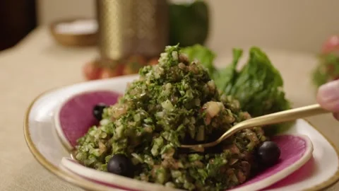 Hand Serving Fresh Turkish Salad with Olives and Greens on a Rustic Table Vídeos de archivo 345217243