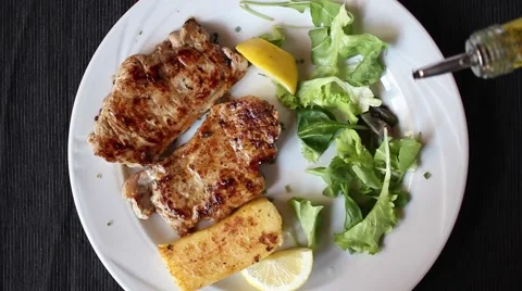 Hand serving meat pork and pouring olive oil Stock Footage 47211365