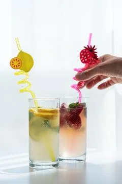 Hand serving refreshing lemon and strawberry drinks Stock Photos