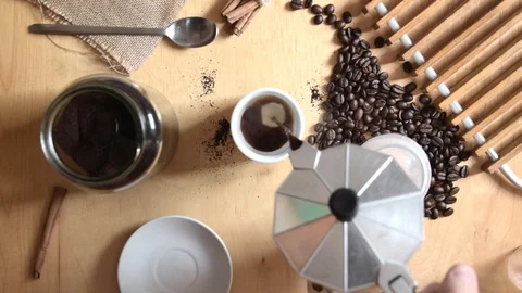 Hand serving some expresso cafe holding a coffee pot on a rustic wooden table Stock Footage 112405387