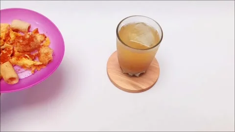 Hand Serving Spicy Macaroni Snack with Traditional Drink Stock-Footage 345275542