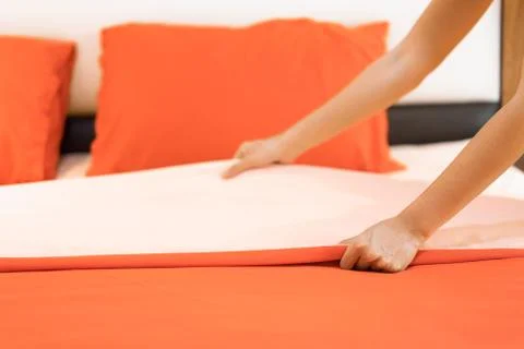 Hand set up white bed sheet in room hotel. Foto stock