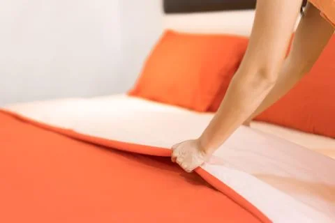 Hand set up white bed sheet in room hotel. Stock Photos