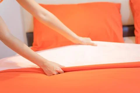 Hand set up white bed sheet in room hotel. Stock Photos