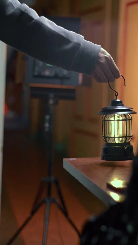 Hand Sets Lamp on Table at Night Stock Footage 309770678