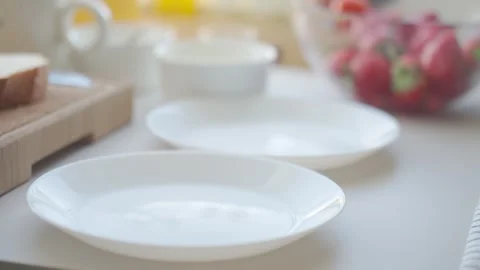 Hand sets plates on a table and places French toast slices onto them Stock Footage 343685115