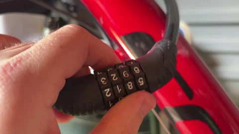 Hand Setting Combination Bike Lock On Red Bicycle Frame Close Up Stock Footage 338362159