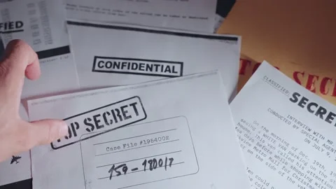 Hand setting down top secret paper on desk along side other classified documents Stock Footage 199994191