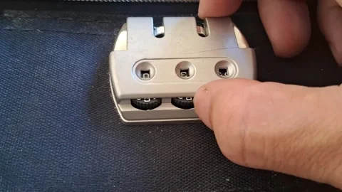 Hand setting silver combination lock on travel luggage video clip Stock Footage 339247310