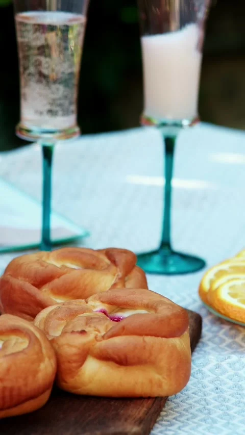 Hand setting upright champagne flutes on patterned picnic table beside wooden Stock Footage 345161857