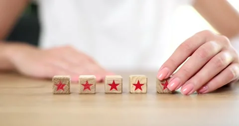 Hand setting wooden block with five star symbol to increase company rating Stock Footage 270918639