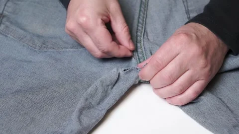 Hand sewing. Man mending torn trousers Stock-Footage 284747059