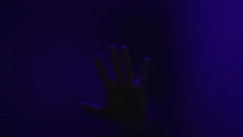 Hand shadow on glass close-up. Black silhouette of man's hand behind glass Stock Footage 153889971