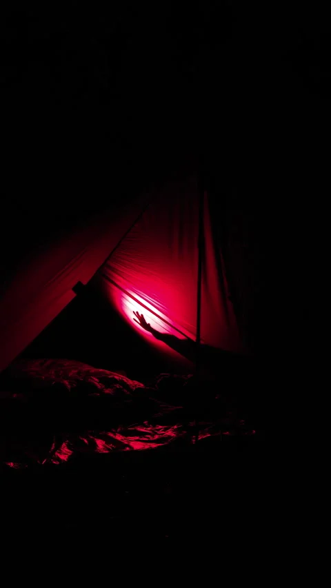 Hand Shadow Moving Across Red Lit Camping Tarp Shelter at Night Stock Footage 345066005