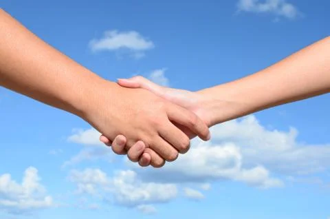 Hand shake between a man and a woman on blue sky background 写真素材