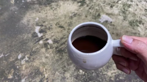 Hand shaking a cup of black coffee Stock Footage 302880579
