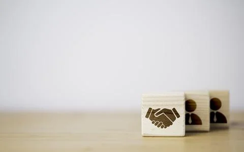 Hand shaking which print screen on wooden cube block in front of human icon.. Stock Photos