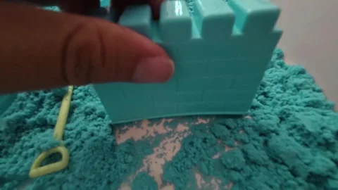 Hand shapes structure in vibrant blue kinetic sand. Stock Footage 329582904