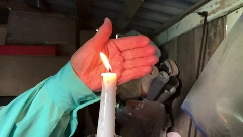 Hand shielding burning candle flame Stock Footage 316980519