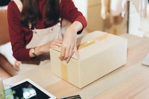 Hand of shop owner packing parcel box preparing for delivery Stock Photos