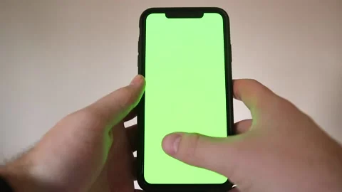 Hand Shot of Young Man Typing and Swiping on Smartphone with Green Screen Stock Footage 148144825