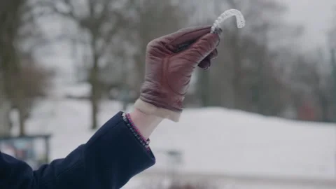 Hand showcasing a clear aligner for teeth regulation, winter day, close up Stock Footage 258553201