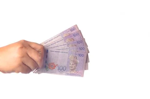 Hand showing 100 Ringgit Malaysia (MYR) money with over white  background and Stock Photos