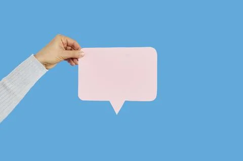 Hand showing blank speech bubble, straight cutting shape, on blue studio Stock Photos