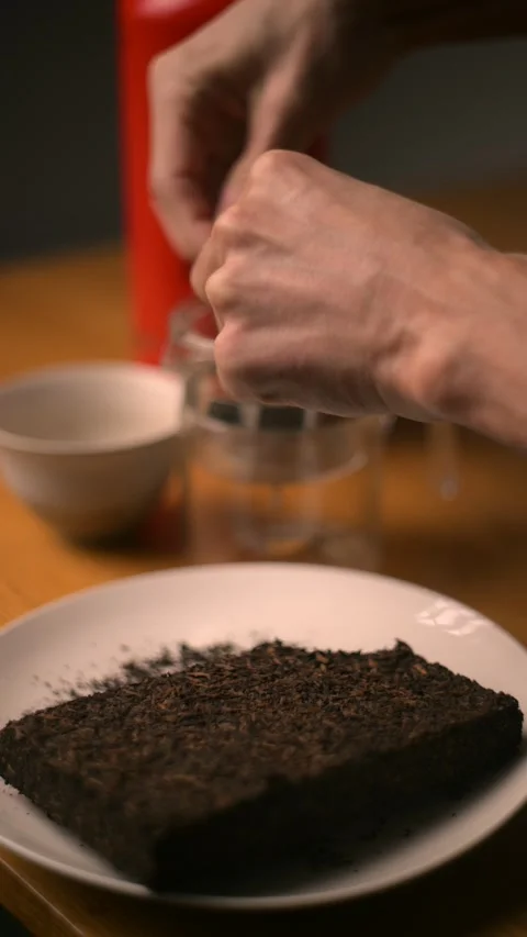 Hand showing a compressed brick of puer tea Stock Footage 303699272
