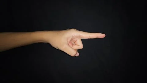 A hand showing a gesture pointing at something. Isolated on black background Stock Photos