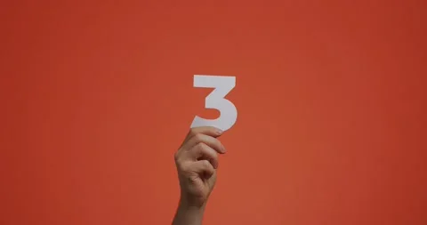 Hand showing number three. Arm with digits, third numeral made of carved paper Stock Footage 157185633