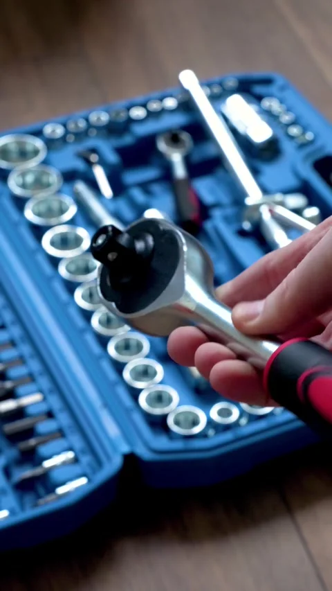 Hand showing a socket wrench in front of an open blue toolbox Stock Footage 346234797
