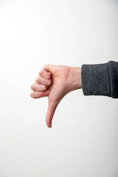 Hand showing thumbs down gesture on a white background, symbolizing dislike.. Stock Photos