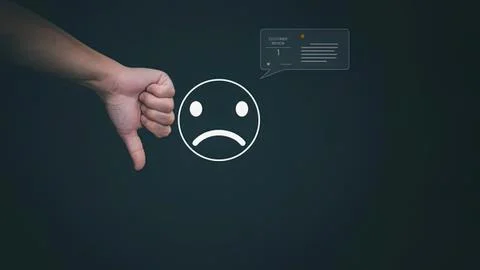 Hand showing thumbs down next to sad face icon and review Stock Photos
