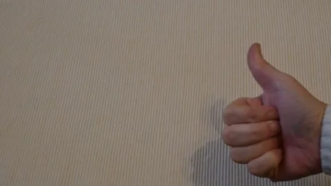 Hand showing thumbs up like gesture on white background Stock Footage 336179737