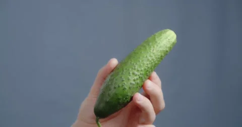 The hand shows a close-up of the cucumber. Видео 169493281