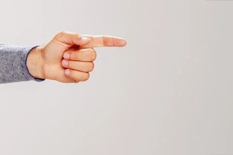 Hand shows direction on grey background 写真素材
